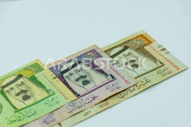 صورة لورقة نقدية من فئة 1 و 5 و 10 ريال سعودي من الإصدار الخامس، صورة الملك عبد الله بن عبد العزيز ال سعود مطبوعة على عملة الريال السعودي، عملة ورقية، مالية واقتصاد، العملة الرسمية للسعودية، خلفية خضراء