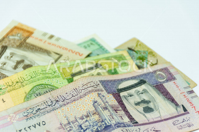 صورة مقربة لأوراق نقدية من عملة الريال السعودي، صورة خادم الحرمين، الملك عبد الله بن عبد العزيز ال سعود مطبوعة على عملة الريال السعودي، عملة ورقية، مالية واقتصاد، العملة الرسمية للسعودية، خلفية بيضاء