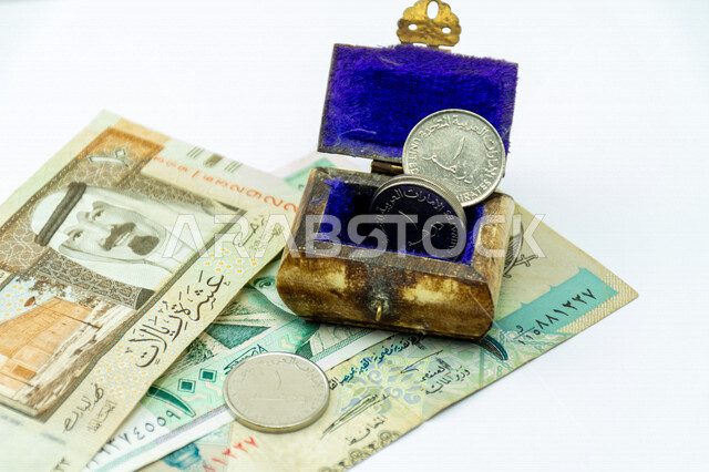 Small box made of ivory with UAE dirham banknotes, Gulf currency notes, Saudi riyal, Custodian of the Two Holy Mosques King Abdullah bin Abdulaziz, Gulf banknotes, investment savings fund, white background