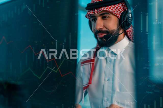 موظف عربي سعودي خليجي يعمل في خدمة العملاء يرتدي سماعة الاتصال، استعلامات واستفسارات، الاجابه على اسئلة العملاء، متابعة الرسم البياني لسوق الاوراق المالية، الاستثمار والتداول في البورصة، خلفية لمخطط بياني مالي بتقنية الهولوجرام ثلاثية الأبعاد