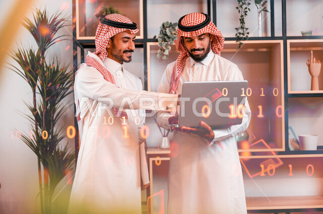 موظفان عربيان خليجيان سعوديان يتناقشان في مقر العمل، زملاء عمل، اتفاقية عمل، بيئة عمل سعودي، استخدام جهاز الحاسوب المحمول، مجموعة من الأرقام والرموز البرمجية بتقنية الهولوجرام ثلاثية الأبعاد، أكواد وخوارزميات، تطوير المواقع والتطبيقات الإلكترونية