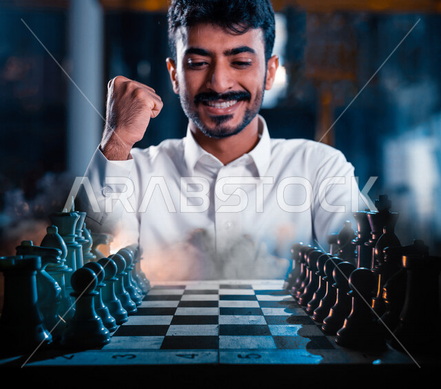 صورة مقربة لشاب عربي سعودي خليجي يلعب لعبة الشطرنج، مفهوم التركيز والتحدي، التخطيط والتفكير، لعبة رقمية استراتيجية على رقعة الشطرنج، إيماءات تدل على الفوز، أنشطة ترفيهية، قضاء أوقات ممتعة في اللعب، تسليه وترفيه