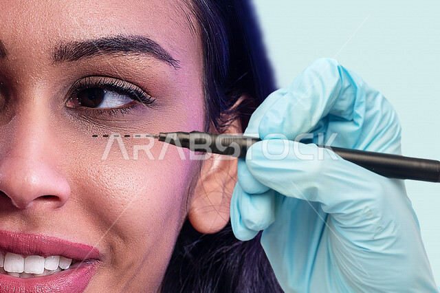 صورة مقربة ليد أخصائية تجميل بلمس ورسم خط تصحيح على وجه إمرأة عربية خليجية سعودية قبل عملية التجميل ، مفهوم العناية والإهتمام بنضارة وتحسين البشرة، جلسات العناية بالبشرة ، مفهوم مكافحة الشيخوخة وجراحة شد الوجه، عيادة تجميلية نسائية