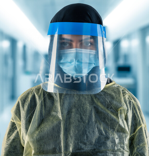 A Saudi Arabian Gulf doctor wearing a mask and a protective plastic mask over it, following safety procedures, avoiding the spread of infection, protective equipment, the concept of medicine and health care, combating the Corona virus