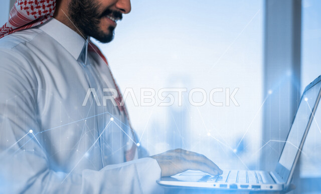 رجل أعمال عربي سعودي خليجي يستخدم جهاز الابتوب، رسوم بيانية إحصائية للبورصة المالية بتقنية الهولوجرام ثلاثية الأبعاد، تطوير الشركات والمشاريع الاقتصادية، التجاره الإلكترونيه، متابعة الأسهم، الإستثمار المالي