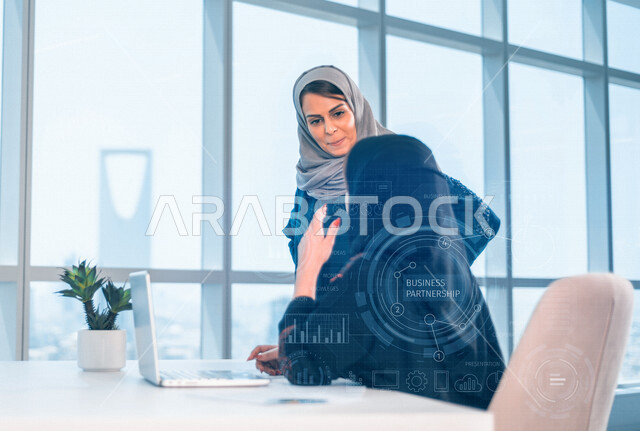 إمرأتان عربيان سعوديتان خليجيتان في مكتب العمل, إجتماع عمل, إدارة المهام، العمل على جهاز الحاسوب، فريق عمل ، مناقشة المشاريع، تطوير الأعمال, شركة عربيه سعودية خليجيه ، بيئة العمل السعودي
