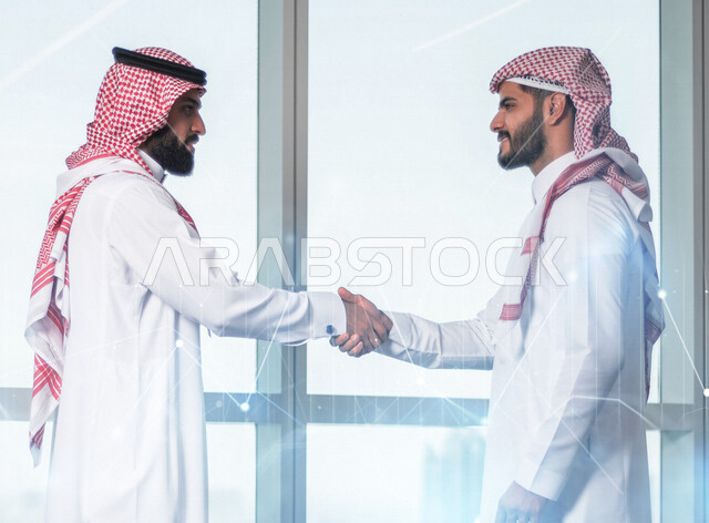 رجلان عربيان سعوديان خليجيان يتصافحان, اتفاقية عمل, صفقة عمل ,  مشروع وخطة عمل جديده, شركاء عمل, تقدم ونجاح, رجال أعمال, بيئة عمل سعودي