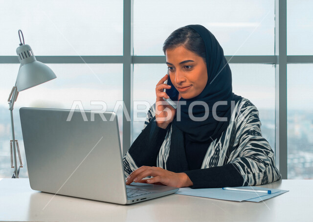 إمرأه عربيه سعوديه خليجيه في مكتب العمل, إجراء مكالمه هاتفيه, إجتماع عمل عن بعد, إدارة المهام، العمل على جهاز الحاسوب ، مناقشة المشاريع، تطوير الأعمال, شركة عربيه سعودية خليجيه ، بيئة العمل السعودي