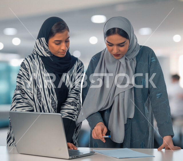 إمرأتان عربيان سعوديتان خليجيتان في مكتب العمل, إجتماع عمل, إدارة المهام، العمل على جهاز الحاسوب، فريق عمل ، مناقشة المشاريع، تطوير الأعمال, شركة عربيه سعودية خليجيه ، بيئة العمل السعودي
