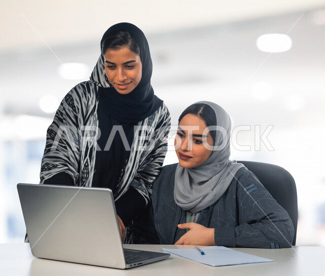 إمرأتان عربيان سعوديتان خليجيتان في مكتب العمل, إجتماع عمل, إدارة المهام، العمل على جهاز الحاسوب، فريق عمل ، مناقشة المشاريع، تطوير الأعمال, شركة عربيه سعودية خليجيه ، بيئة العمل السعودي
