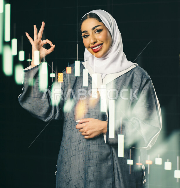 سيدة اعمال عربية خليجية سعودية تحمل جهاز التابلت  ، متابعة مخطط الرسم البياني للنمو الاقتصادي ، التداول في سوق الاوراق المالية ، مراقبة الاقتصاد والمعلومات المالية ، الاستثمار المالي ،خلفية الرسم البياني للسوق المالي