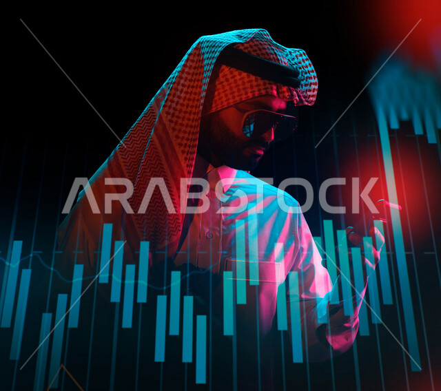A Saudi Arabian Gulf man using a mobile phone, stock exchange statistical charts with 3D hologram technology, development of companies and economic projects, e-commerce, stock tracking, financial investment