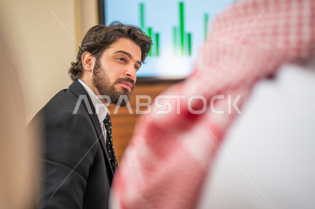 فريق عمل عربي خليجي سعودي في اجتماع عمل مع عميل جديد يرتدي البدلة الرسمية، تطوير المشاريع، دراسة وتحليل المشاريع الجديدة، تقييم العمل الشراكي، الشراكة والتعاون، اجتماعات عمل، ورش عمل وتدريب