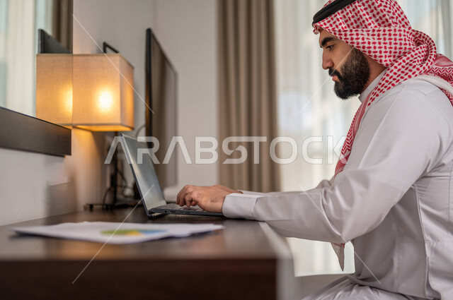 رجل عربي خليجي سعودي يقوم بتحليل البيانات على الحاسوب المحمول، متابعة مخطط الرسم البياني، تدقيق وتحليل بيانات المشروع، دراسة مشاريع جديدة، صعود وهبوط البورصة، النمو الاقتصادي، الاستثمار المالي