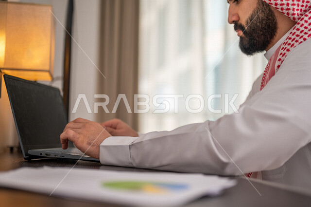 رجل عربي خليجي سعودي يقوم بتحليل البيانات على الحاسوب المحمول، متابعة مخطط الرسم البياني، تدقيق وتحليل بيانات المشروع، دراسة مشاريع جديدة، صعود وهبوط البورصة، النمو الاقتصادي، الاستثمار المالي