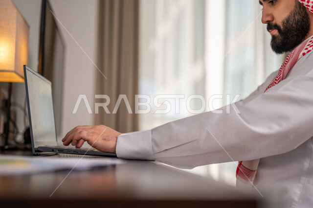 A Saudi Arabian Gulf man analyzes data on a laptop, follows up the chart, audits and analyzes project data, studies new projects, rises and falls in the stock market, economic growth, financial investment