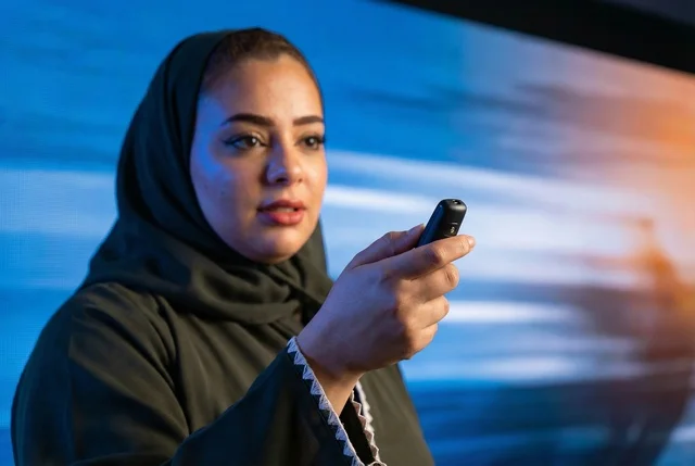Saudi Businesswoman in Abaya Holding Presentation Clicker Saudi Businesswoman in Abaya Holding Presentation Clicker
