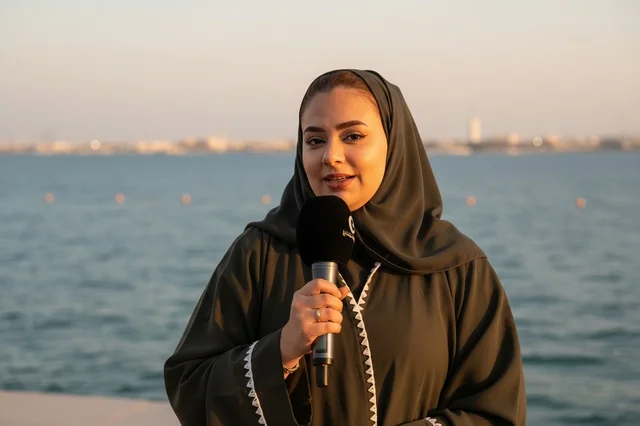 Saudi Female Journalist with Microphone by the Sea