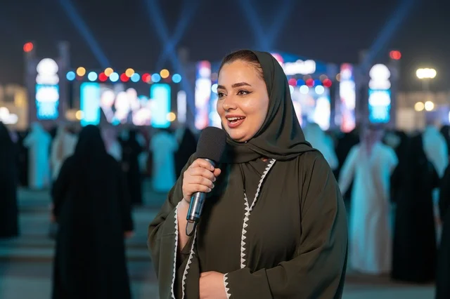 Saudi Female Reporter Holding Microphone at Night Festival