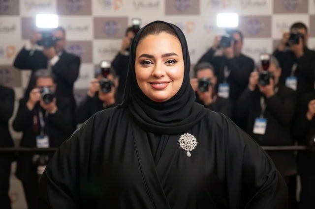 امرأة سعودية بالعباءة السوداء على السجادة الحمراء