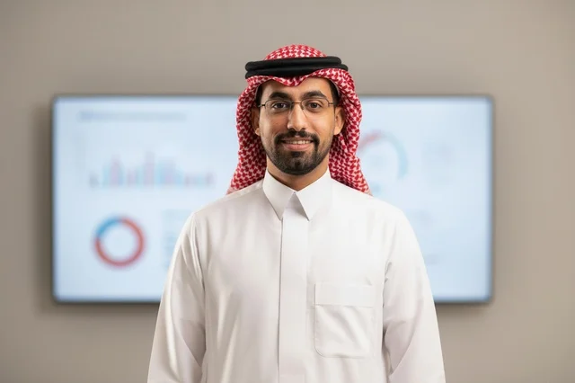 رجل أعمال سعودي في المكتب أمام شاشة الرسوم البيانية
