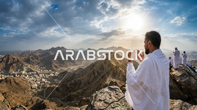 حاج سعودي بملابس الإحرام يدعو على جبل مكة عند الشروق