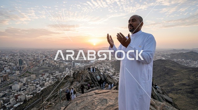رجل سعودي يدعو فوق قمة جبل في مكة المكرمة وقت الغروب