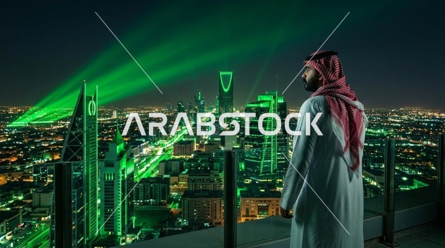رجل سعودي ينظر إلى أفق مدينة الرياض ليلاً