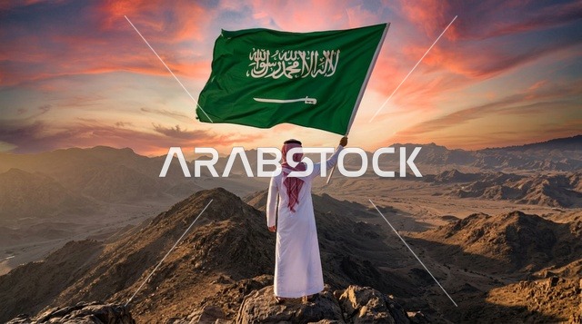 مواطن سعودي يحمل العلم الوطني فوق الكثبان الرملية