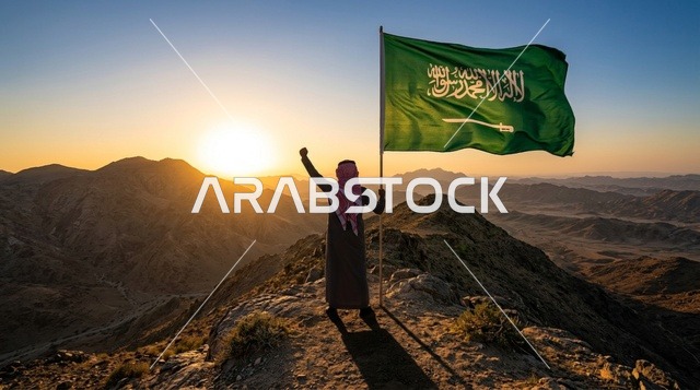 مواطن سعودي يحمل العلم الوطني فوق الكثبان الرملية