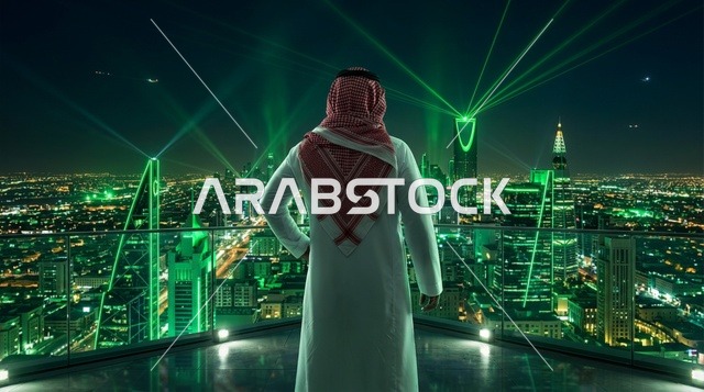 رجل سعودي بالزي التقليدي يطل على أفق مدينة الرياض ليلا