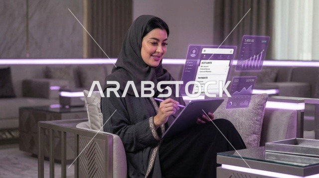 امرأة سعودية تستخدم جهاز لوحي مع شاشات هولوجرام مالية