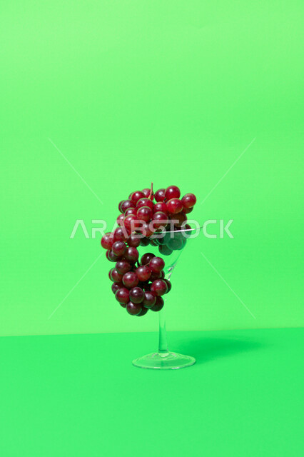 صورة لفاكهة العنب الأرجواني اللذيذ مصورة على خلفية خضراء ( كروما ) ، فاكهة العنب الصحية اللذيذة تظهر على شكل عناقيد ، فاكهة صيفية
