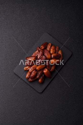 Dried dates on a ceramic plate for Ramadan or Iftar. Dried dates as a food background for your design