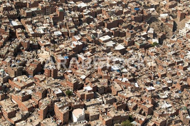 مشهد حضري كثيف مليء بالمباني المبنية من الطوب المتراصة بإحكام والشوارع الضيقة.