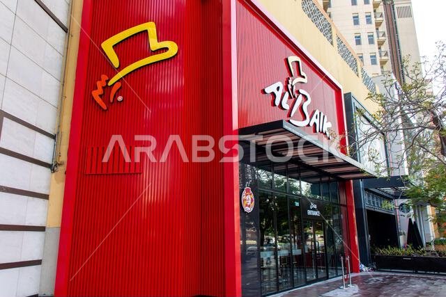 Exterior view of the iconic Al Baik fast food restaurant with its signature red facade and logo, located at Al Ghurair Centre, Dubai, UAE.