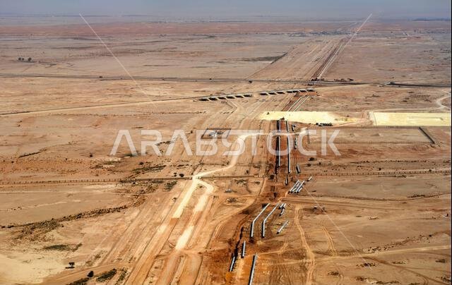 صورة جوية لمشروع تركيب خط أنابيب رئيسي ومشروع بنية تحتية عبر المناظر الطبيعية الصحراوية القاحلة خارج الرياض في المملكة العربية السعودية