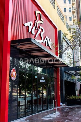 Exterior view of the iconic Al Baik fast food restaurant with its signature red facade and logo, located at Al Ghurair Centre, Dubai, UAE.