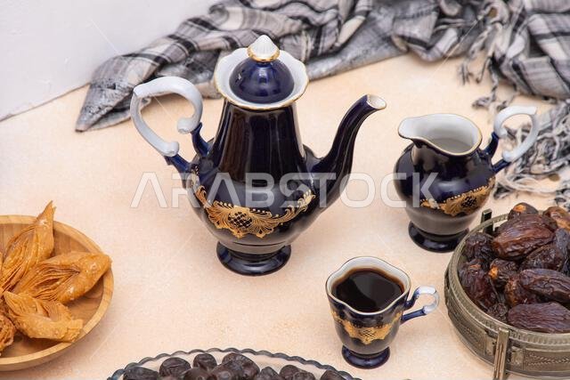 Coffee set with decanter, creamer, and cups. Vintage tableware. Oriental sweets and coffee on table. Baklava, halva, Dates fruit for dessert. Food and drink.