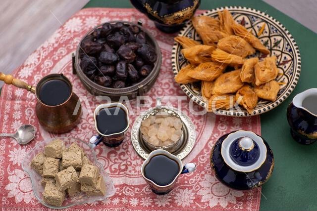 Oriental sweets and coffee on the table. Baklava, halva, Dates fruit for dessert. Food and drink in cezve. Oriental sweets and coffee on the table. Baklava, halva, Dates fruit for dessert. Food and drink in cezve.