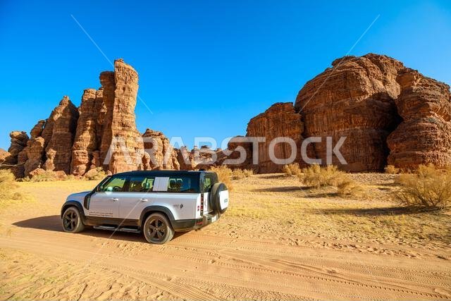 AlUla, Saudi Arabia,Jan 5, 2025: Majestic sandstone mountains in the setting sun at AlUla Sharaan Nature Reserve, viewed from a 4x4 car driving