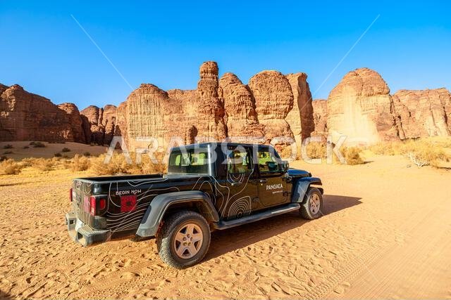 AlUla, Saudi Arabia,Jan 5, 2025: Majestic sandstone mountains in the setting sun at AlUla Sharaan Nature Reserve, viewed from a 4x4 car driving