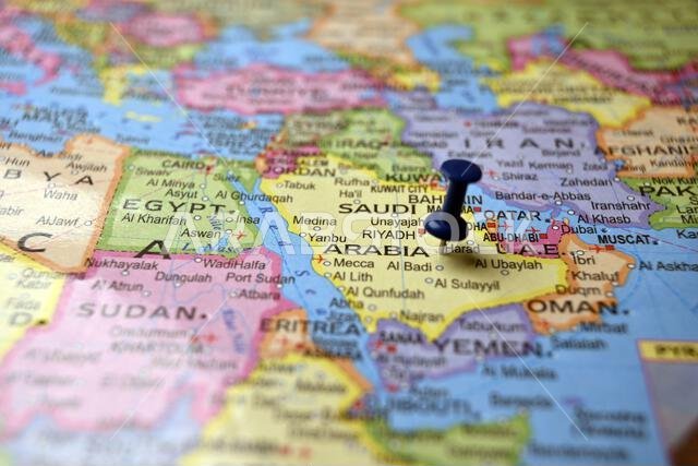 دبوس أزرق يبرز المملكة العربية السعودية على خريطة العالم الورقية القديمة (تصوير فوتوغرافي ماكرو)