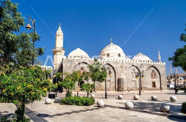 تقف الواجهة الحجرية التاريخية والقباب البيضاء لمسجد الغمامة شامخة في سماء زرقاء صافية في المدينة المنورة المقدسة بالمملكة العربية السعودية.