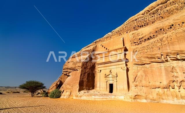 مقبرة نبطية من عصور ما قبل التاريخ منحوتة في جرف من الحجر الرملي في الحِجر، وهو موقع تراث عالمي لليونسكو في العلا، المملكة العربية السعودية.