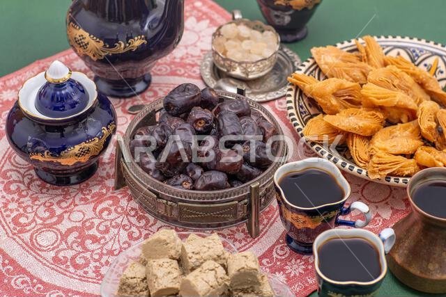 Sweets and coffee cups on the table. Baklava, halva, Dates fruit for dessert. Food and drink. Sweets and coffee cups on the table. Baklava, halva, Dates fruit for dessert. Food and drink.