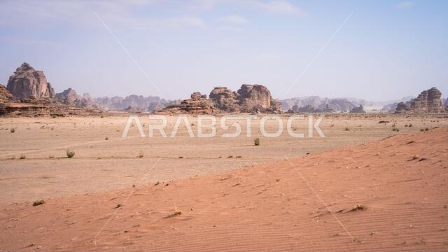 منظر صحراوي قاحل ذو رمال وتكوينات صخرية ضخمة من الحجر الرملي، تبوك، المملكة العربية السعودية