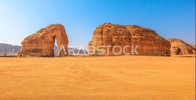 يرتفع جبل الفيل من الرمال البرتقالية الشاسعة في العلا، المملكة العربية السعودية، وهو تكوين مهيب من الحجر الرملي تحت سماء زرقاء صافية في منطقة نائية
