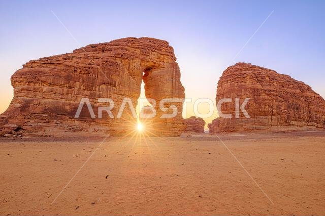 يرتفع جبل الفيل من الرمال البرتقالية الشاسعة في العلا، المملكة العربية السعودية، وهو تكوين مهيب من الحجر الرملي تحت سماء زرقاء صافية في منطقة نائية