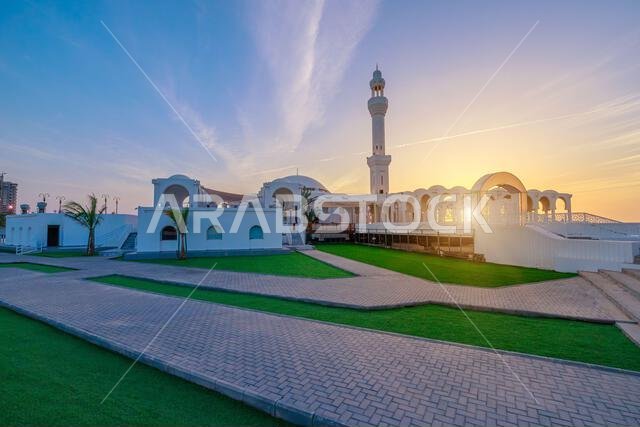 مسجد الرحمة المطل على البحر الأحمر في جدة، المملكة العربية السعودية، ومبنى نادي اليخوت JYC جدة يشكلان مشهداً خلاباً ليلاً